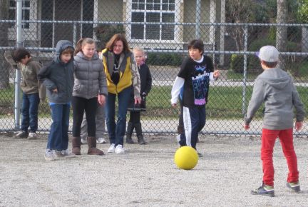 A group of friends forming a circle during a Club G game of California Kickball, showing collective mattering over solo self‑esteem.