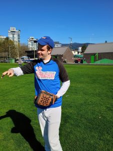 A young man with impairments playing baseball on a field